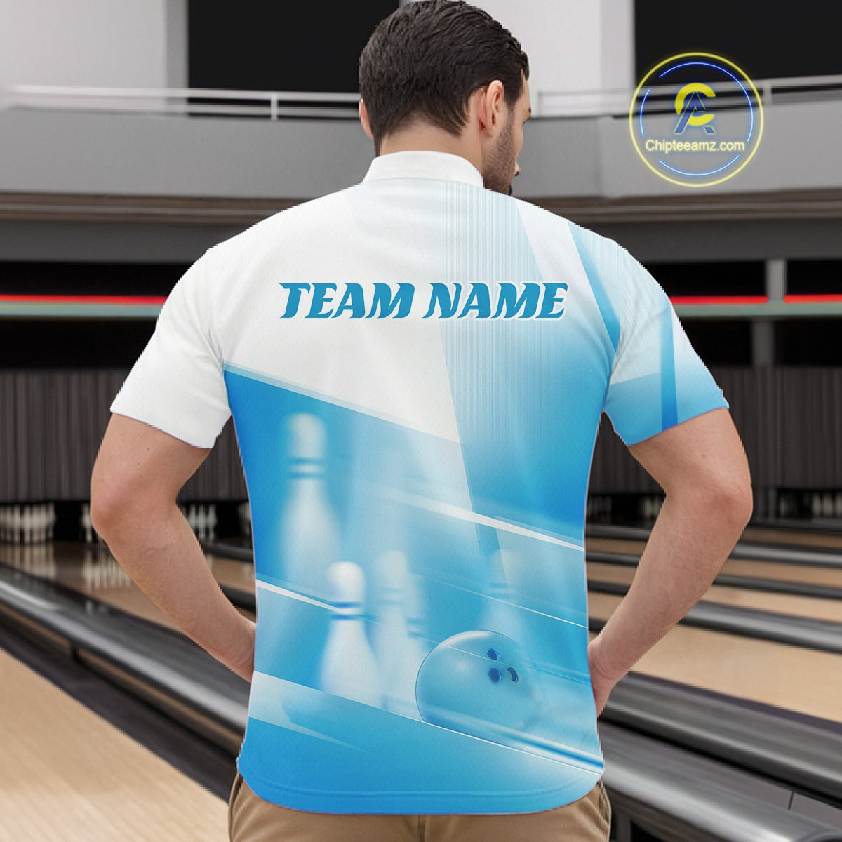Front view male model at a bowling lane wearing a white and blue quarter zip shirt with bowling ball and pins geometric graphics.
