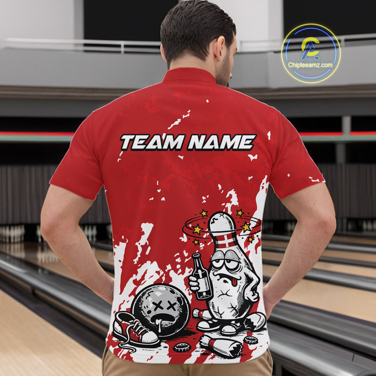 In a bowling lane, male model wearing a red and white quarter-zip shirt, humorous drunk cartoon bowling pin holding a beer bottle and bowling ball with splatter-style background artwork.