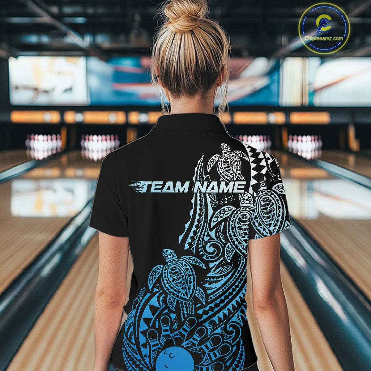 Back view of a female model in a black and blue bowling polo shirt showcasing turtle-themed Polynesian bowling artwork.