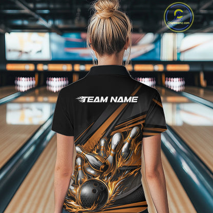 Female model in a bowling lane wearing a black polo shirt, back view featuring gold flame bowling ball striking pins with abstract geometric stripe design