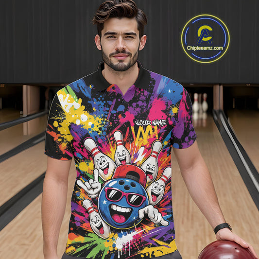 A man wearing a vibrant bowling-themed graphic polo shirt stands in a bowling alley holding a bowling ball. The shirt features a colorful paint splatter background with cartoon bowling pins, a blue bowling ball character, and a black collar.