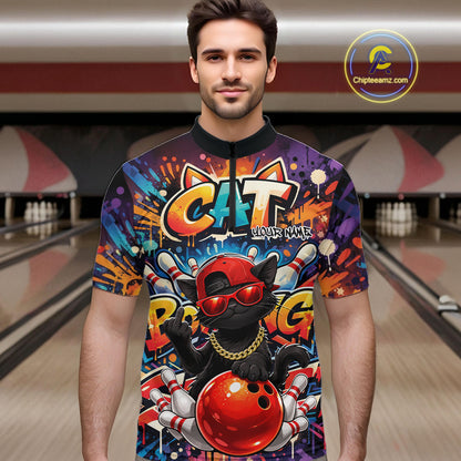Male model at a bowling lane wearing a colorful quarter-zip bowling shirt with graffiti-style black cat artwork, sunglasses, cap, and bowling ball graphics.
