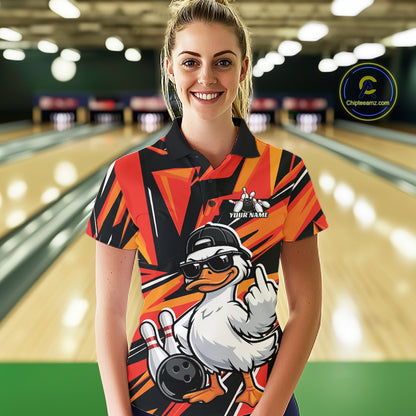 Female model wearing a black and orange bowling polo featuring a duck in sunglasses and cap with bowling lane-inspired artwork.