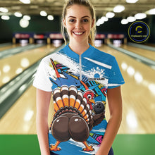 Load image into Gallery viewer, Front view of a happy female model in a bowling alley wearing a blue custom quarter zip bowling shirt with a funny graffiti turkey holding a bowling ball, paint splatter accents, and a personalized name.