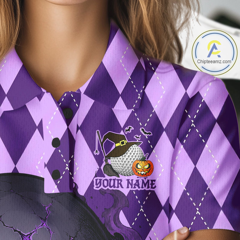 A close-up of a person wearing a purple argyle short-sleeve collared shirt with a Halloween-themed golf ball graphic featuring a witch hat, pumpkin, and the text 'YOUR NAME'.