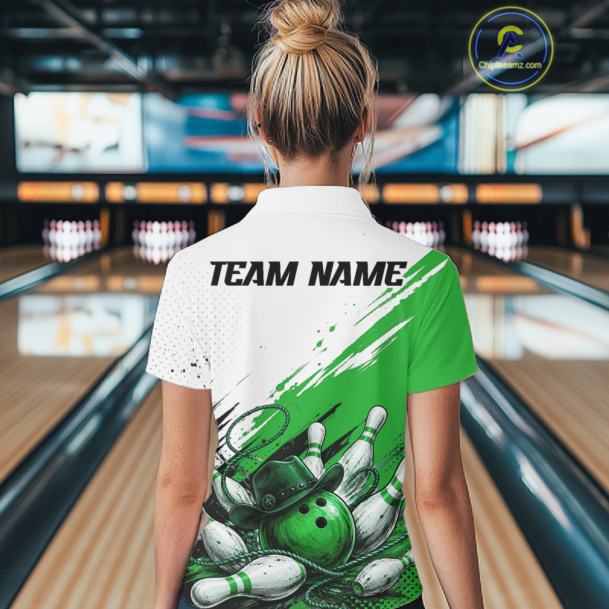 A woman viewed from behind wearing a custom bowling-themed short-sleeve polo shirt with a white and green design, standing in a bowling alley. The shirt features the text 'TEAM NAME' on the back and a graphic of bowling balls and pins.
