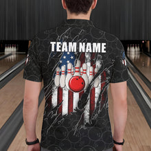 Load image into Gallery viewer, Back view of man wearing a vintage American flag black bowling polo shirt inside a bowling alley.