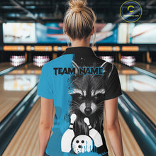 Load image into Gallery viewer, Back view of woman wearing a black and blue raccoon bowling polo shirt inside a bowling alley.
