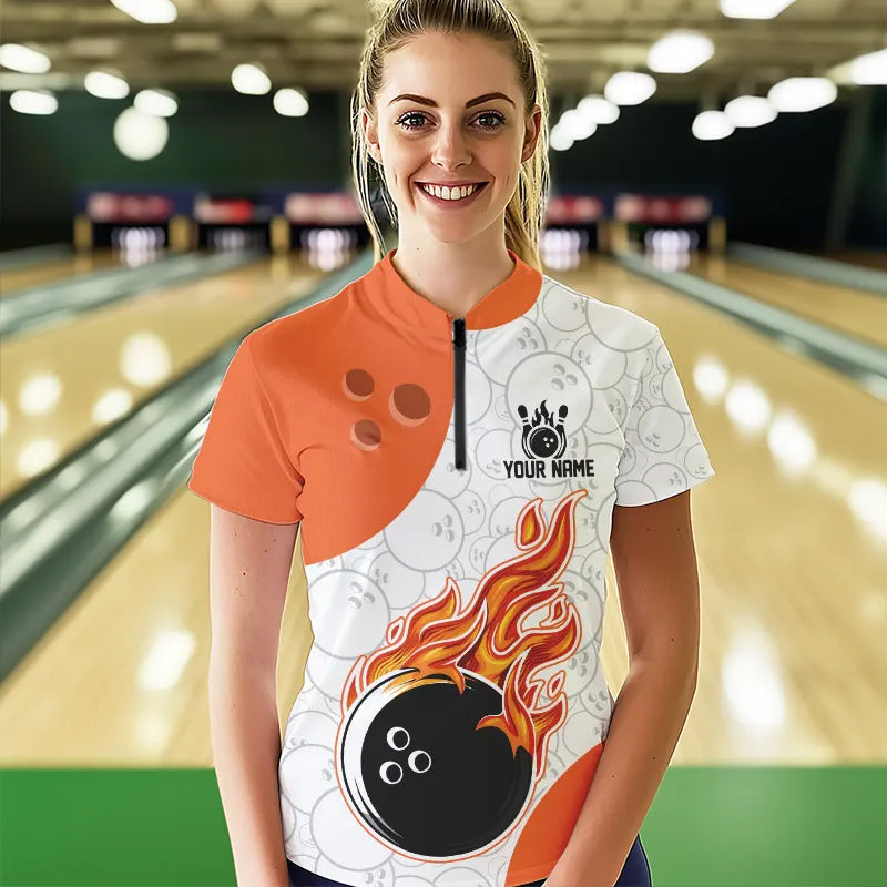 Person wearing a custom bowling shirt with a flame design in a bowling alley.